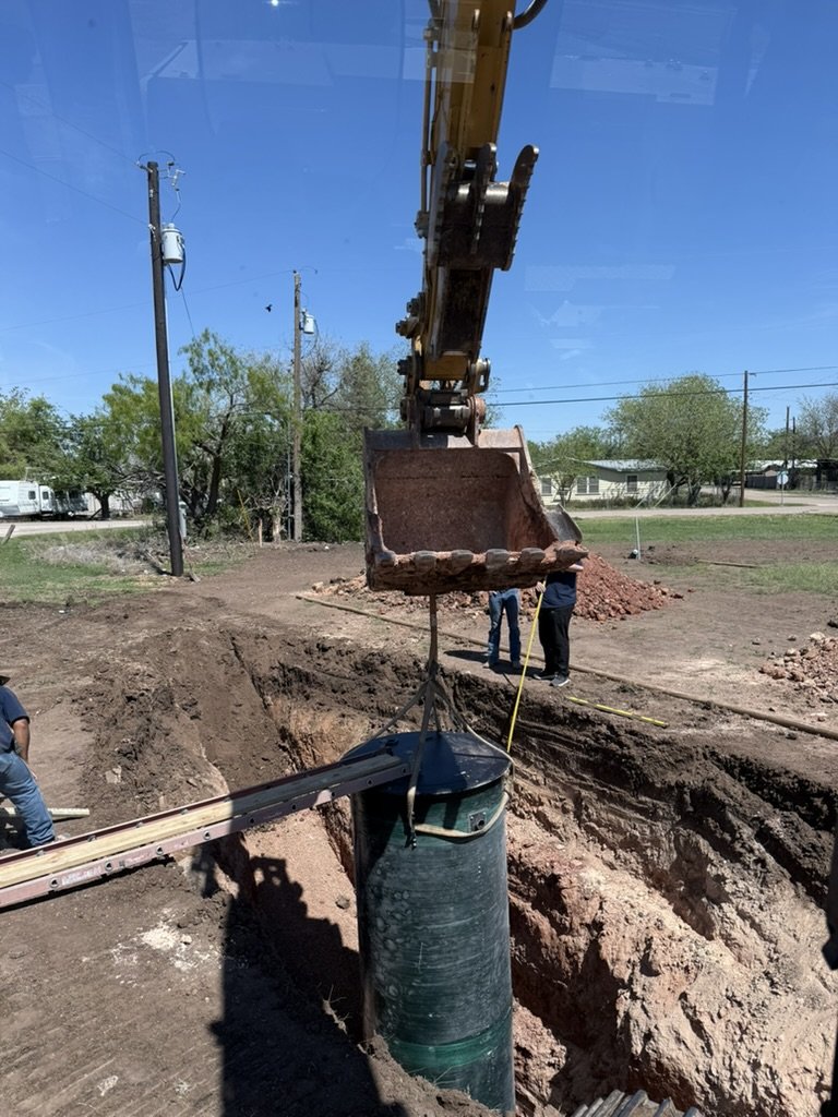 CAT excavator setting septic tank — precision excavation