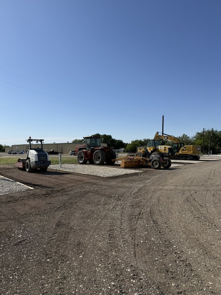 Site prep fleet — compactor, tractor, and CAT excavator